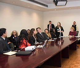 students sit in a boardroom in a meeting