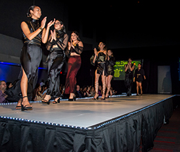 Students walk a runway at a fashion show 