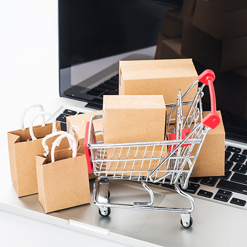 Shopping cart and boxes on a laptop keyboard