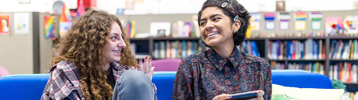 Two smiling students at the Pride Center.