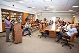 Many individuals fill a library room together