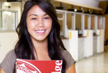 Female Student smiling carrying a folder.