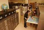 Students looking at maps in a room.