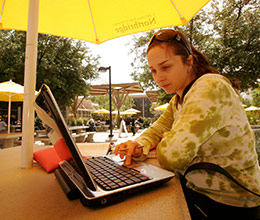 A Student on their laptop outside
