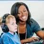 adult helps child using assistive technology